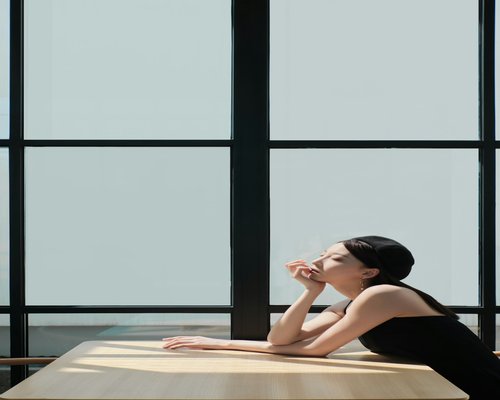 Office worker taking a break and drinking water near a sunny window